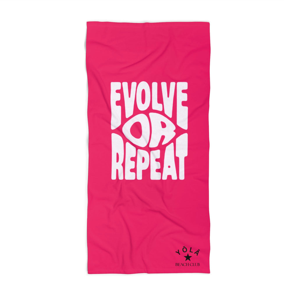Pink towel with white text 'Evolve Loop Repeat' on a white background
