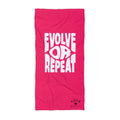 Pink towel with white text 'Evolve Loop Repeat' on a white background