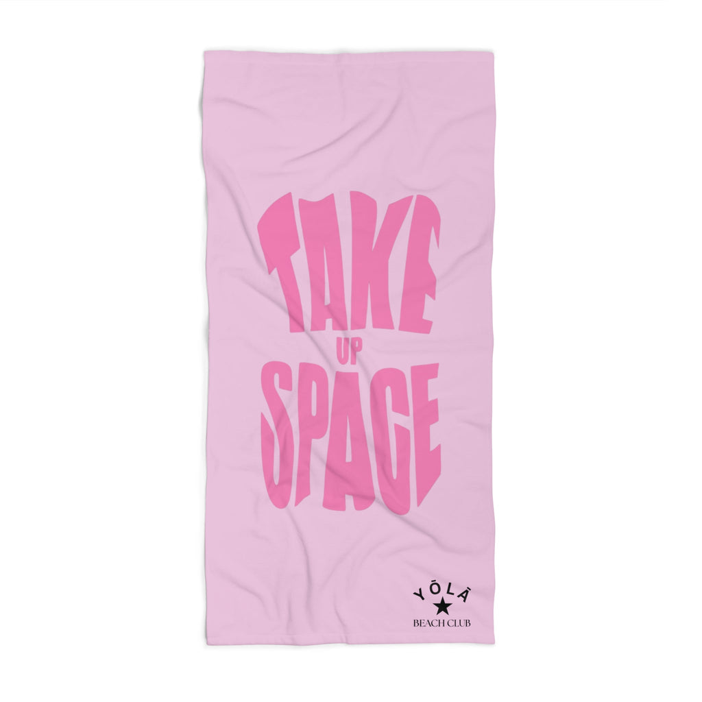 Pink towel with 'Take Up Space' text on a white background