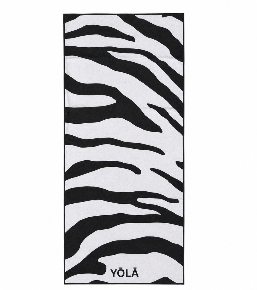 YŌLĀ SCULP'T Zebra Grip Towel featuring a black and white zebra print, made from premium microfiber suede with a non-slip silicone dot backing for hot Pilates and yoga.
