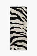 Black and white zebra-print yoga mat towel with abstract stripes, laid flat vertically by YOLA