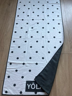 YŌLĀ SCULP'T Polka Princess Grip Towel with a white and black polka dot print, premium microfiber suede, sweat-activated grip, and non-slip silicone dot backing for hot Pilates, hot yoga, barre, and studio workouts.