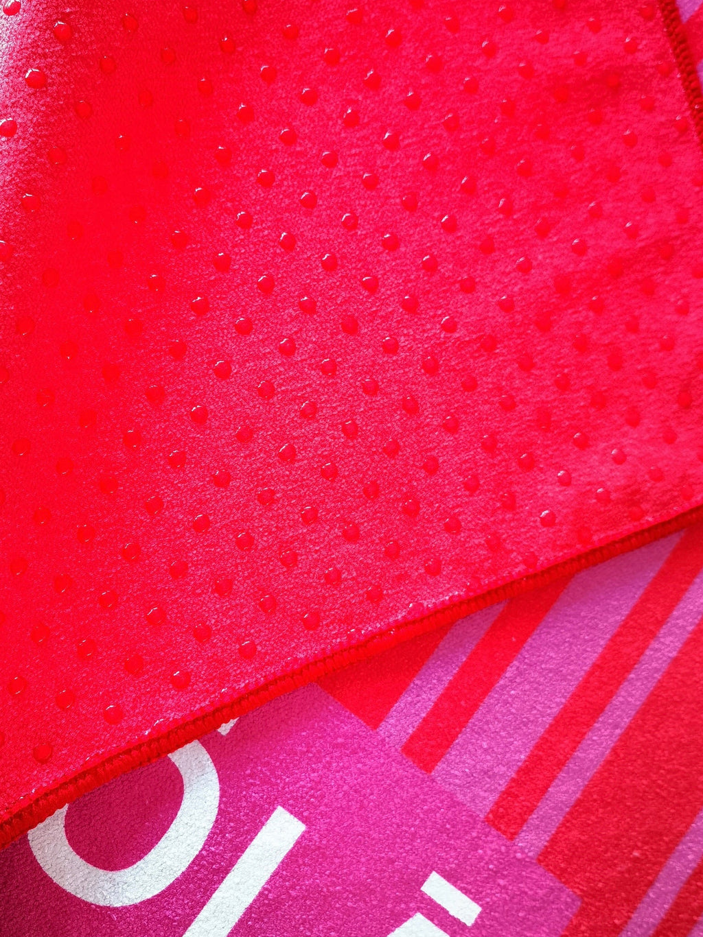 Close-up of sun-kissed yoga mat towel showing non-slip silicone grip dots on microfiber backing by Yola